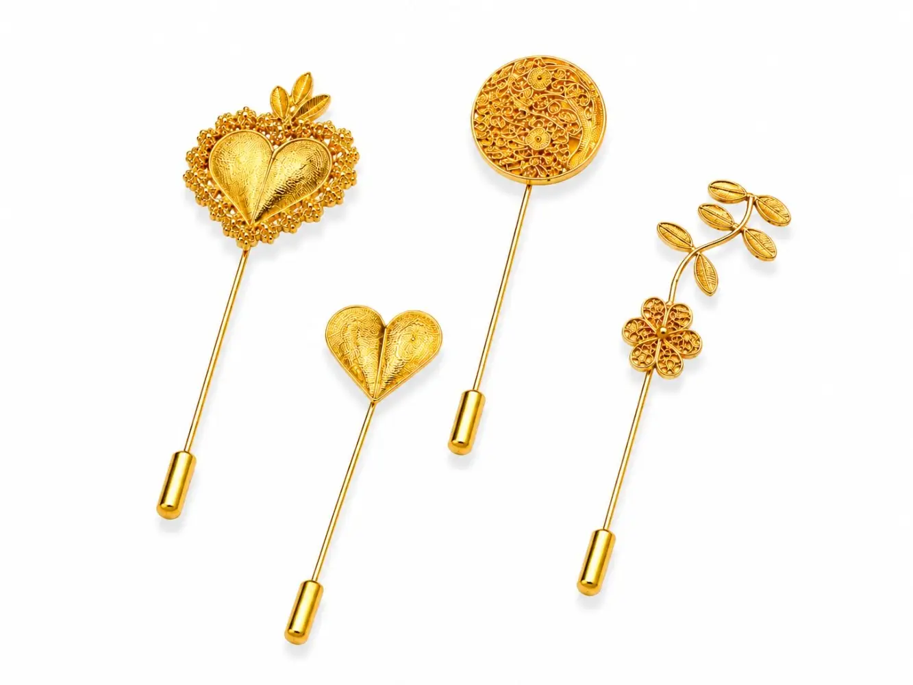 Alfileres y broches artesanales en oro con motivos de filigrana, corazones y detalles botánicos.