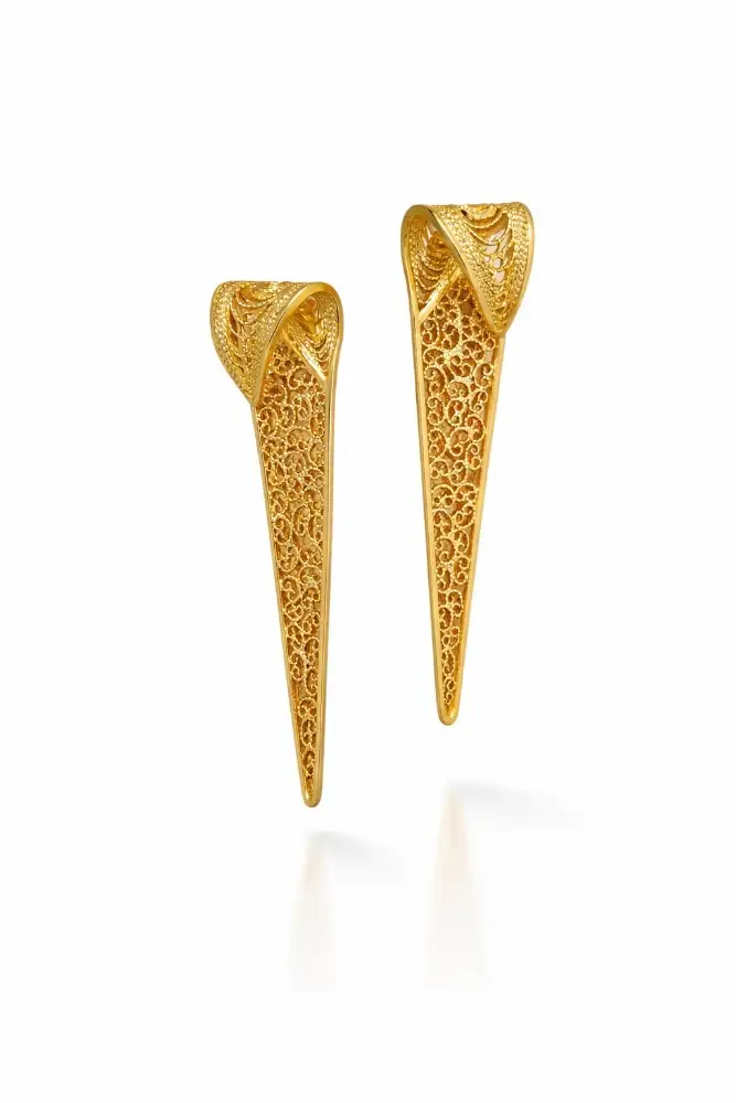 Pendientes largos de silueta cónica e intrincada filigrana dorada, con un moderno diseño superior curvado.